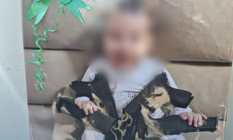 תינוק מחייך מחזיק בתחמושת: התמונה המפתיעה שאיתרו השוטרים